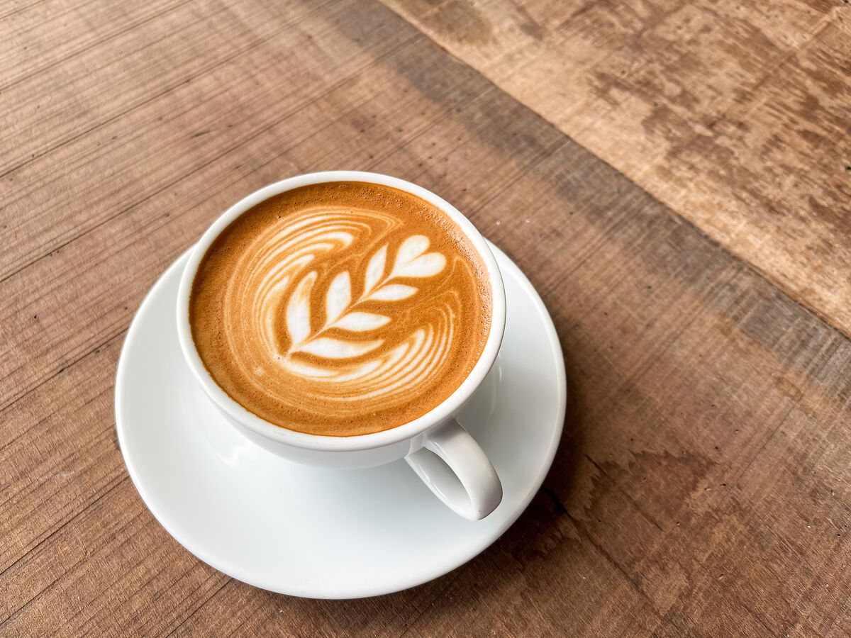 Kop koffie met latte art op een houten tafel